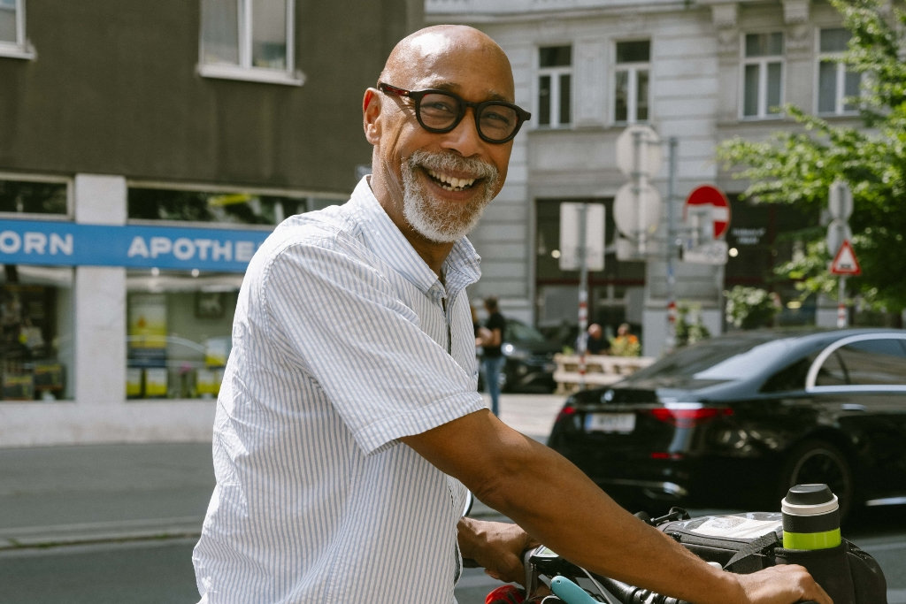 Lachender Mann mit Brille im urbanen Verkehrsbild